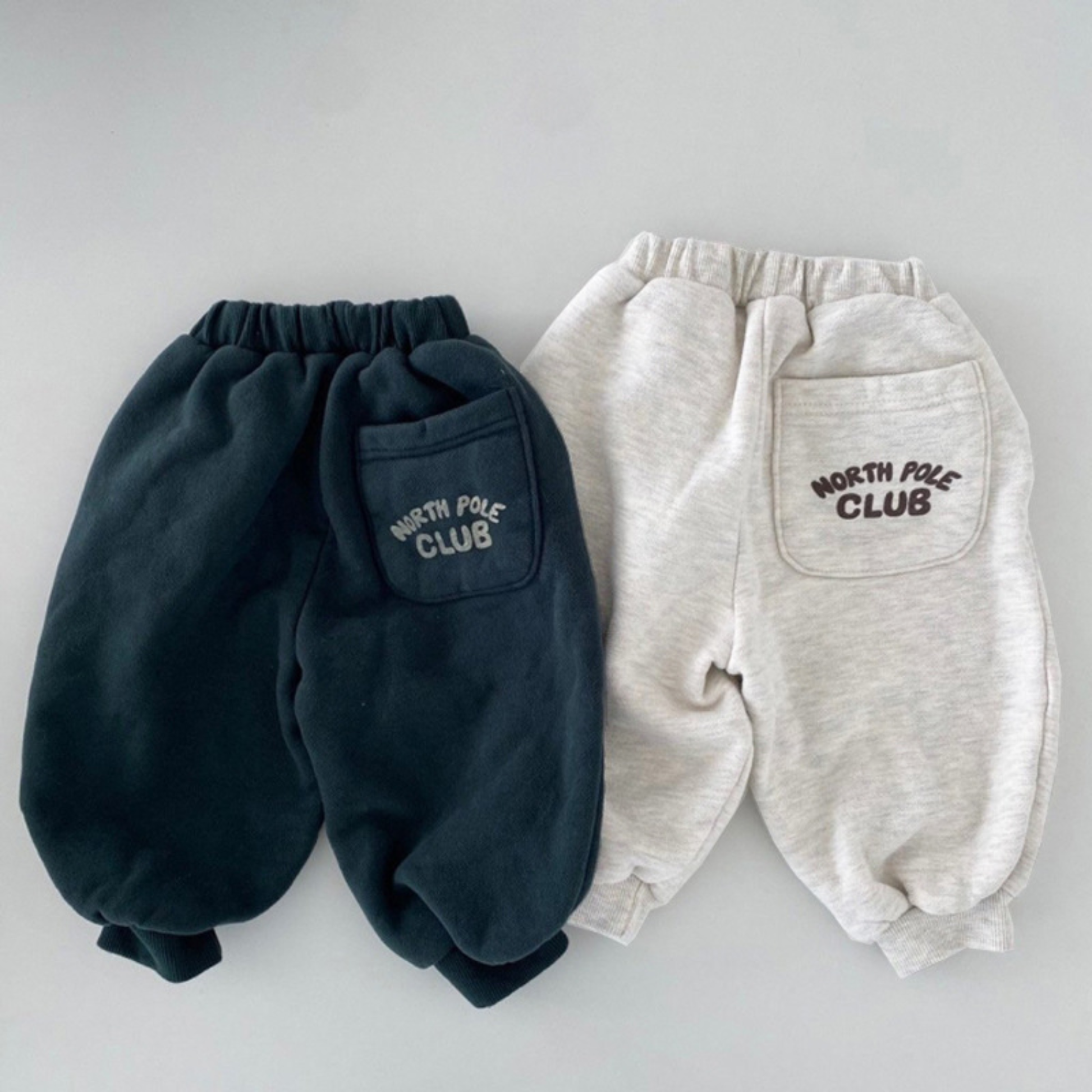 fleece jogger sets in navy blue and ivory, featuring half-zip tops with number 9 embroidery and matching jogger pants, laid flat on a white background.